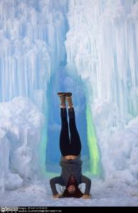 Picture of someone doing a headstand in front of a frozen waterfall